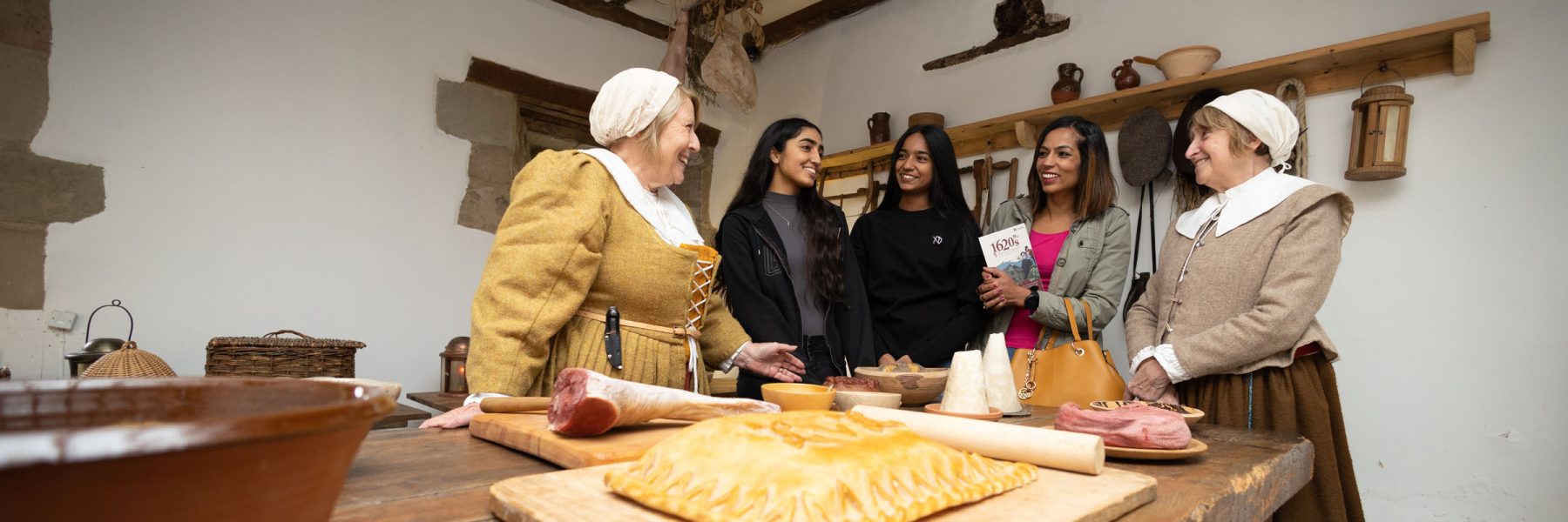 Costumed House Volunteers With A Family In The Scullery Aspect Ratio 1800 600